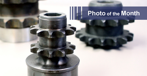 Three sprocket-like metal components, one in focus. Close-up photo with a 