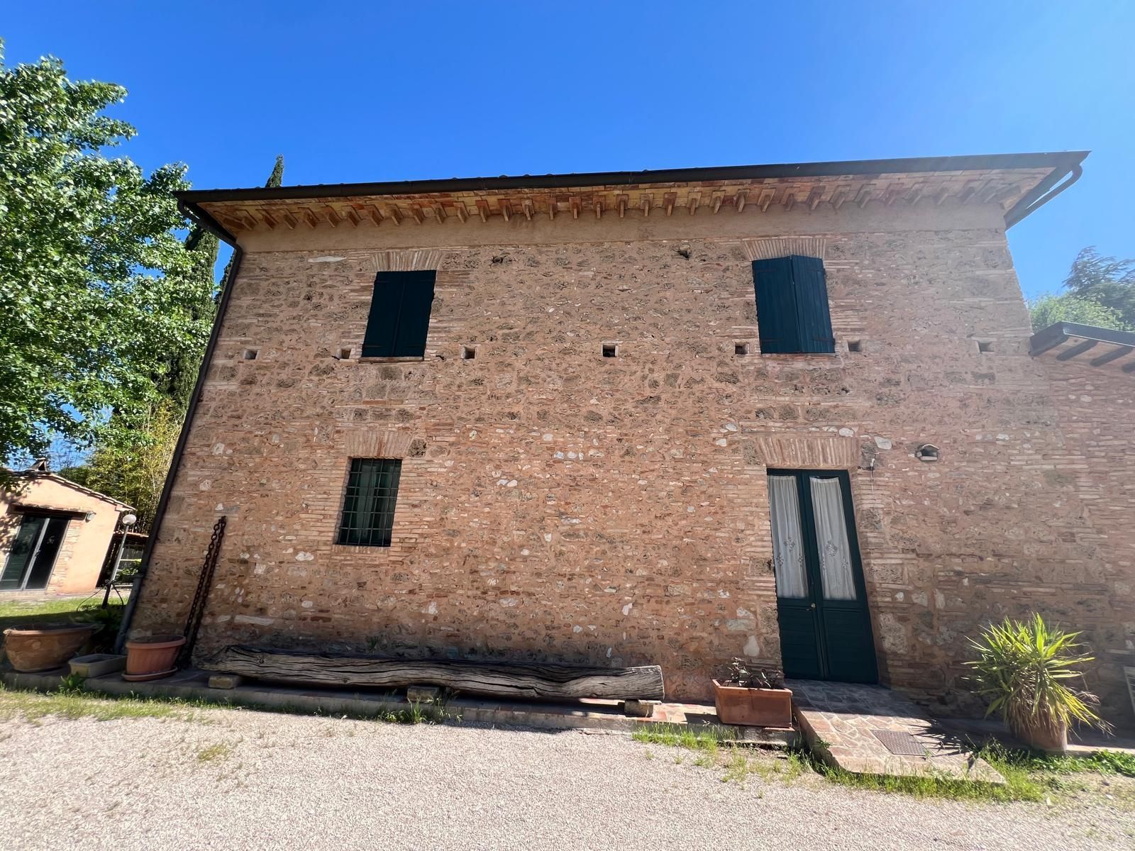 Un grande edificio in mattoni con una porta verde e un cielo azzurro sullo sfondo.