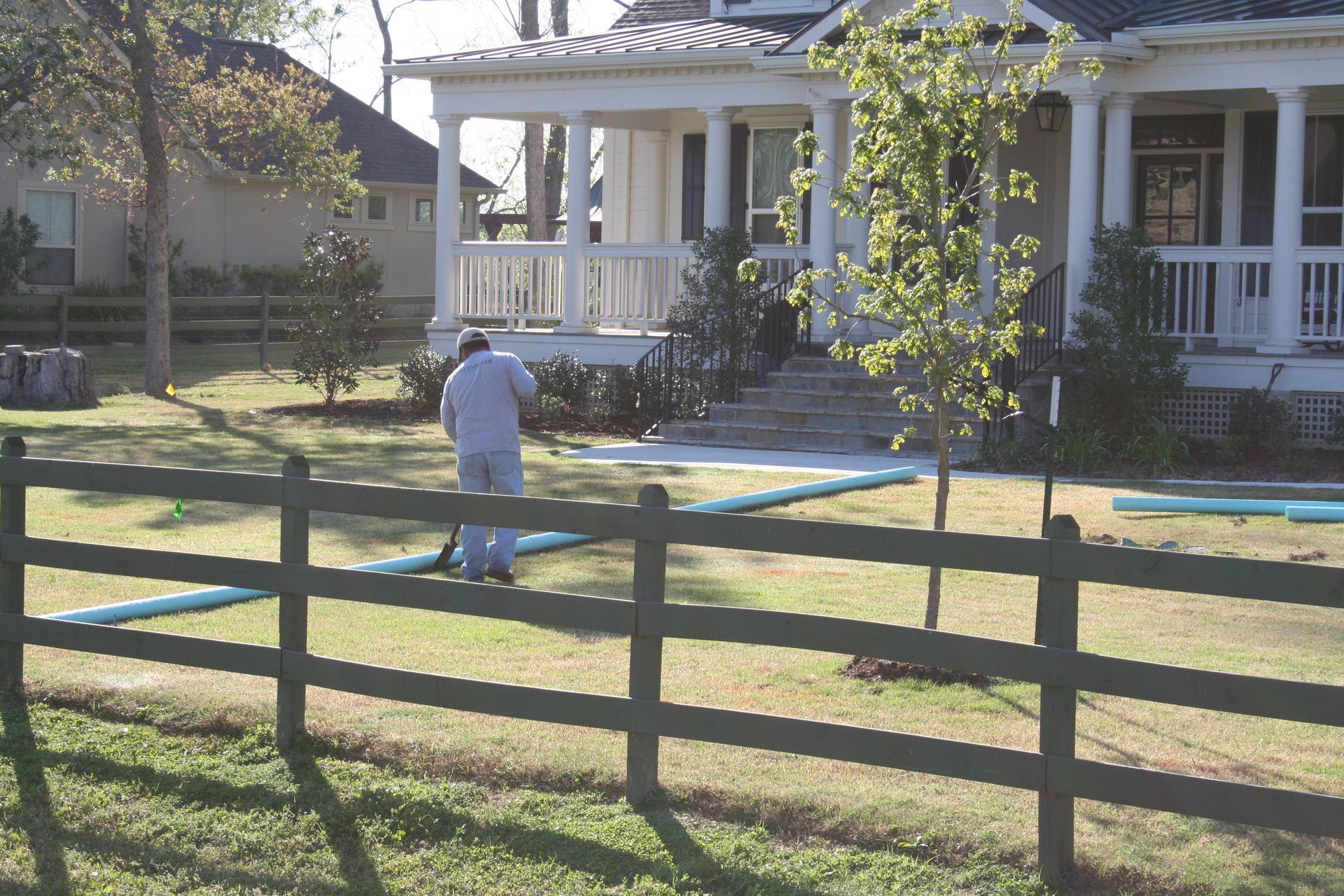 A man standing on a fence in front of a house