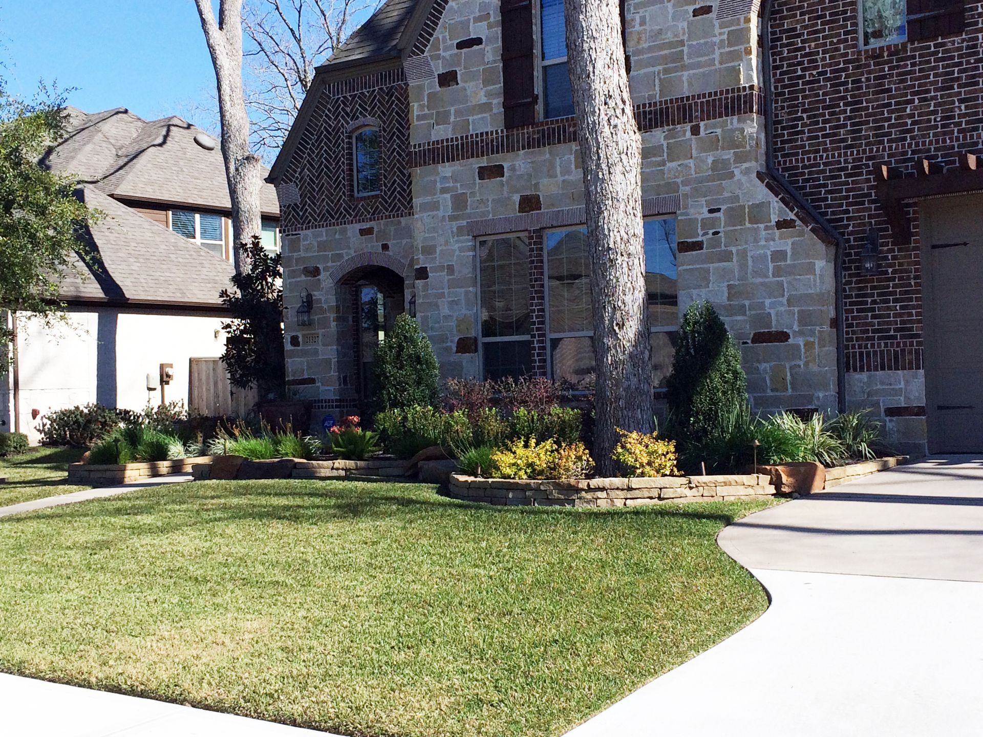 A large brick house with a lush green lawn in front of it
