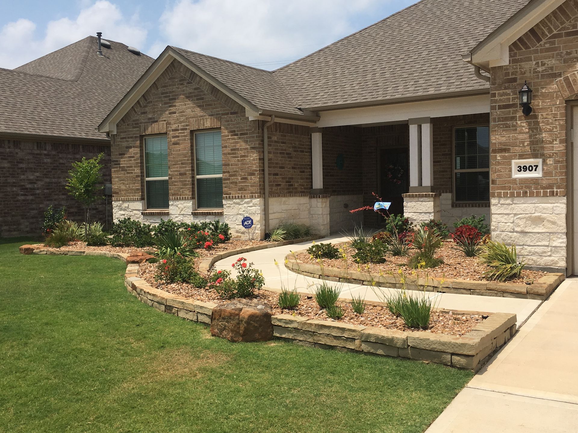 A brick house with a walkway leading to the front door