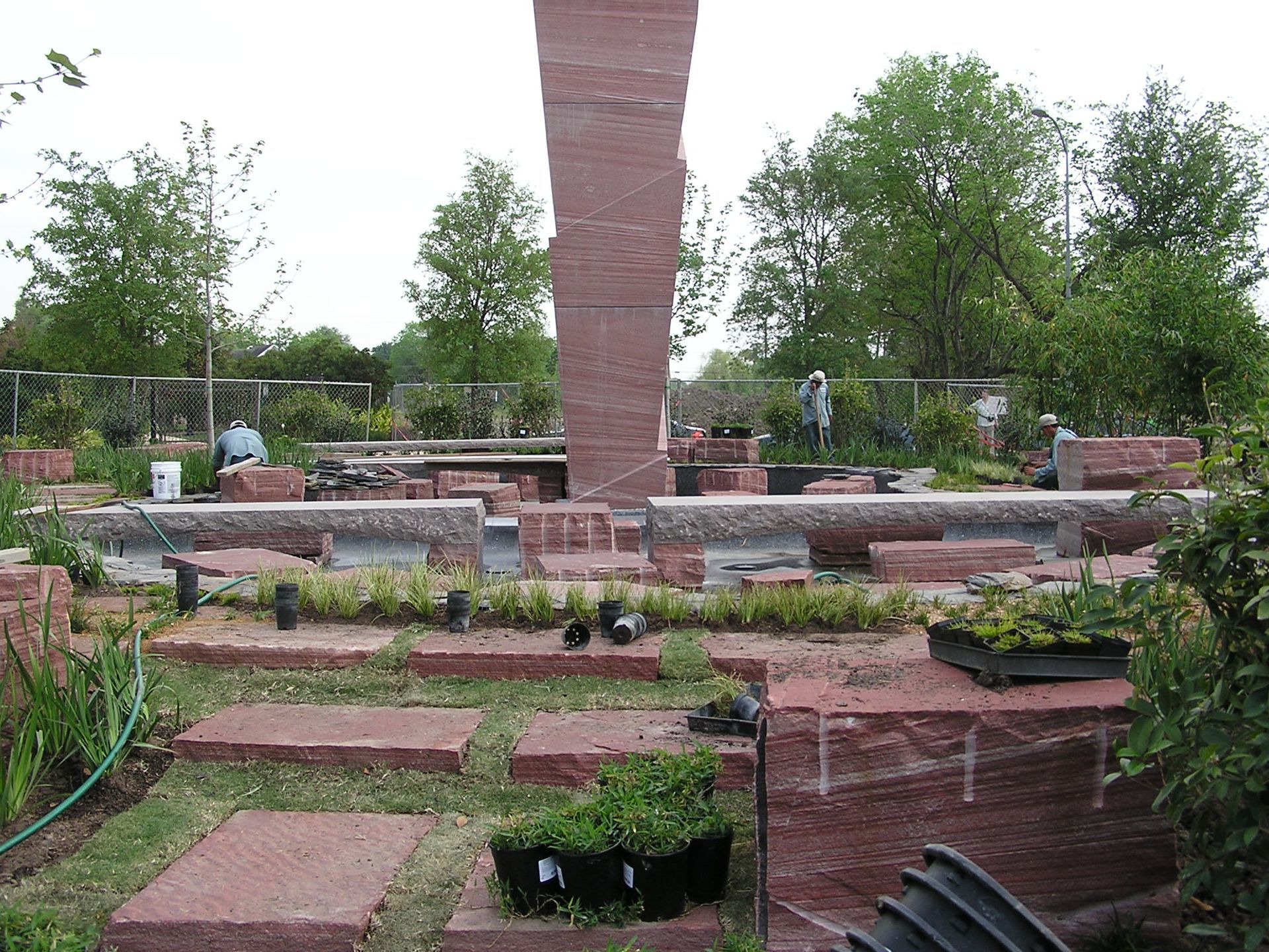 A large brick structure is being built in a garden