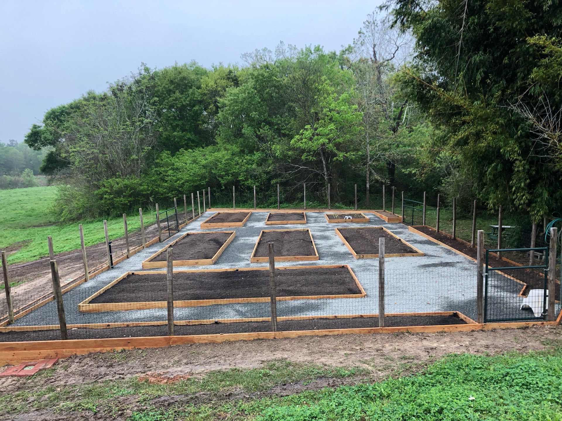 A garden is being built in a field with a fence around it.