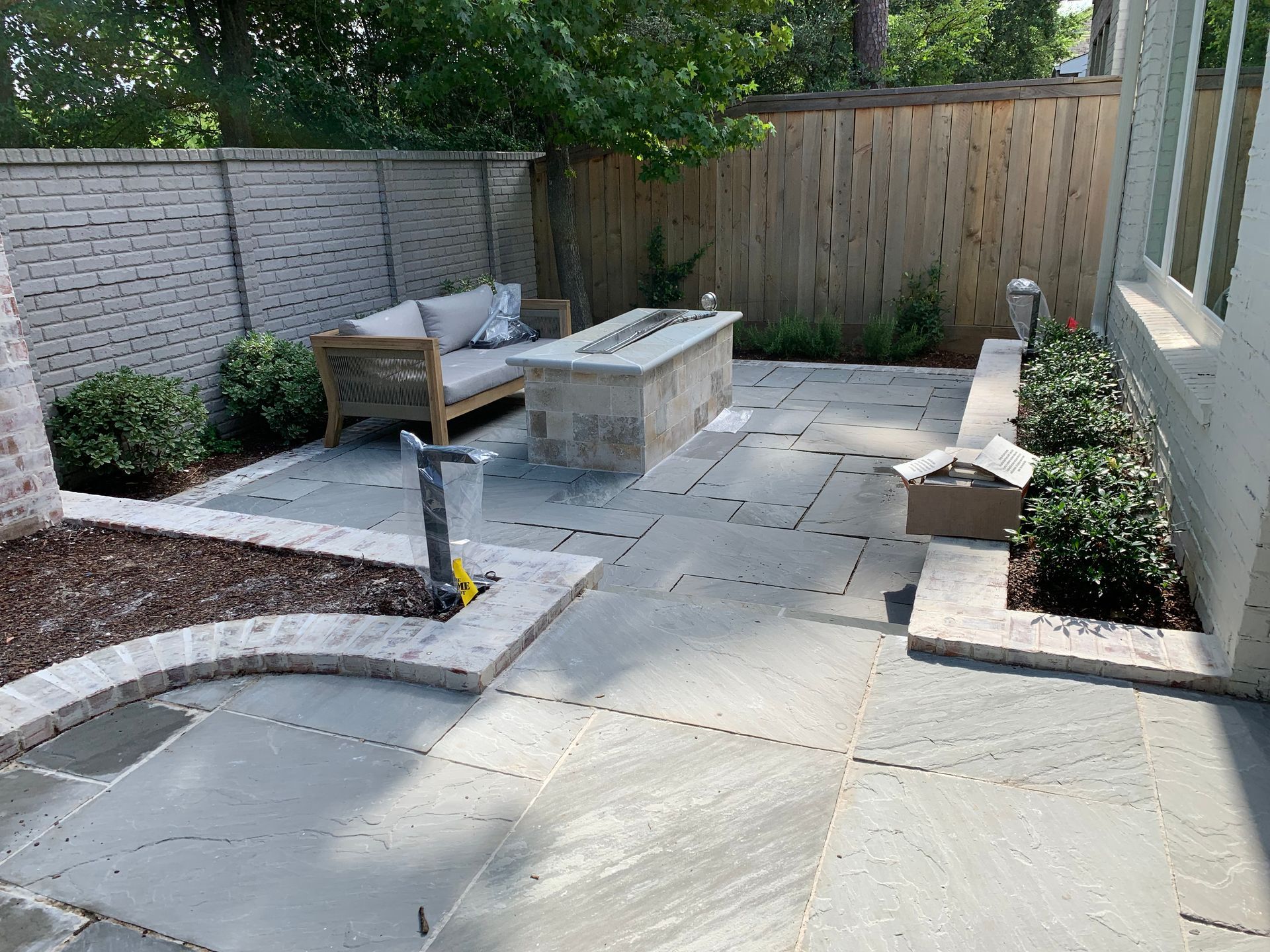 A patio with a fire pit and a couch in the backyard.