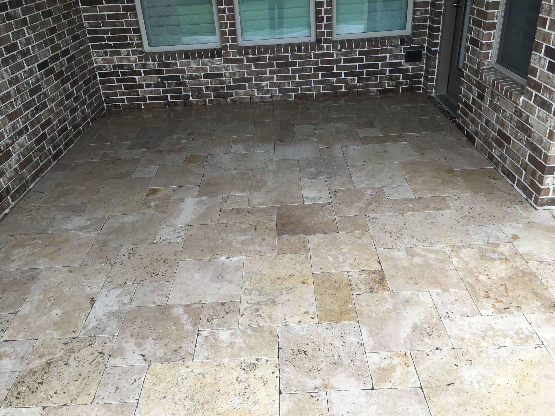 A brick wall with a tiled floor in front of it