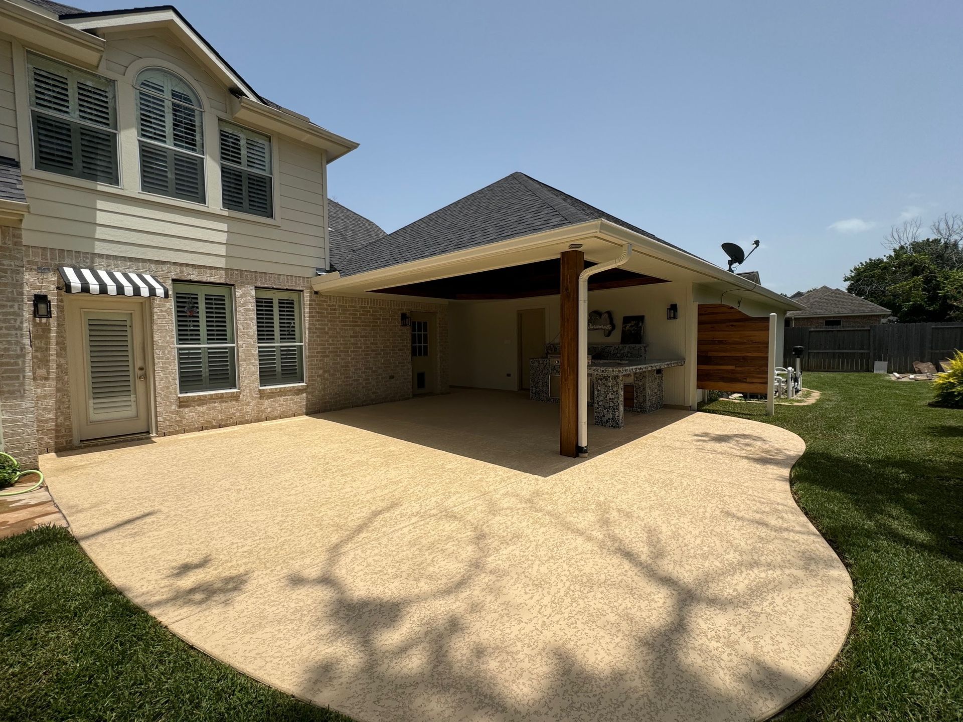A large house with a covered patio in front of it.