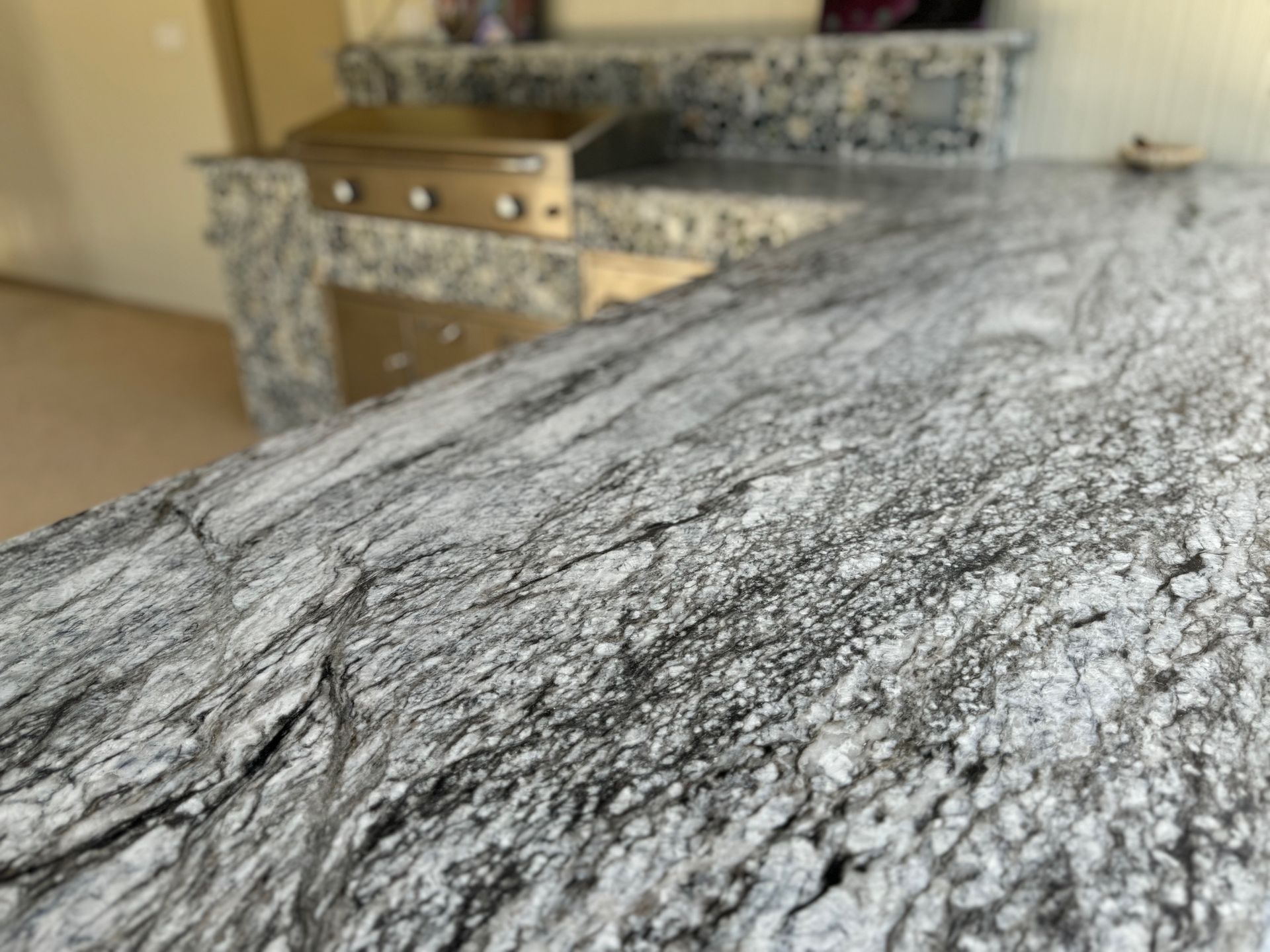 A close up of a granite counter top in a kitchen.