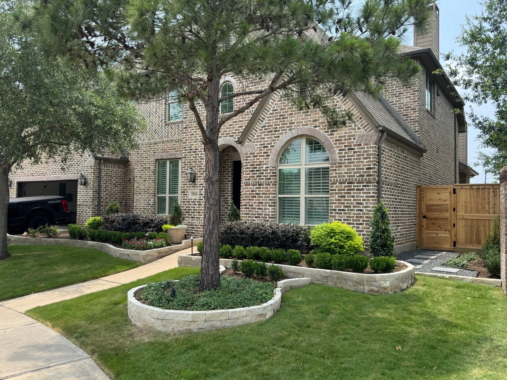 A large brick house with a large tree in front of it.