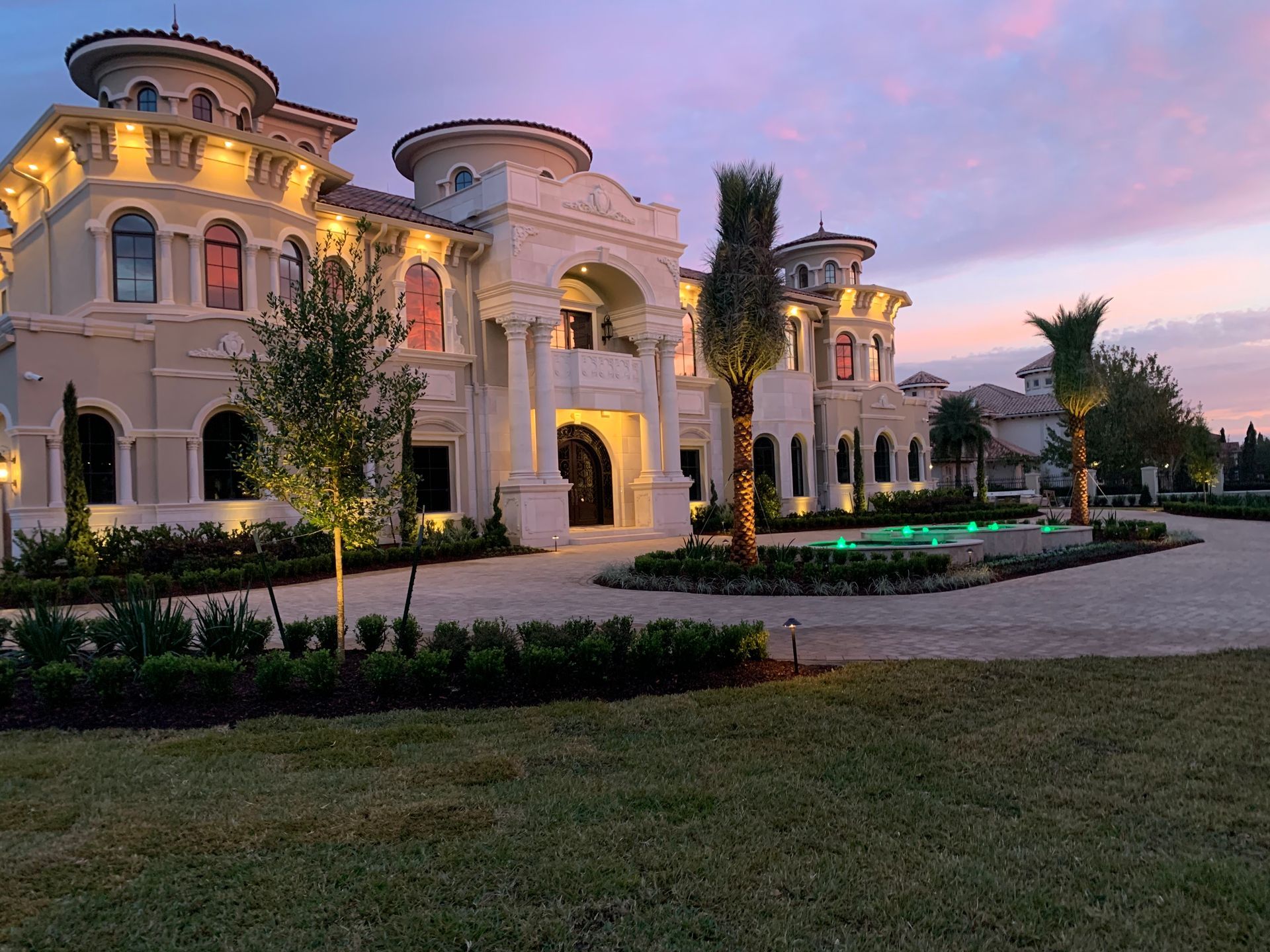 A large house with a lot of windows is lit up at night