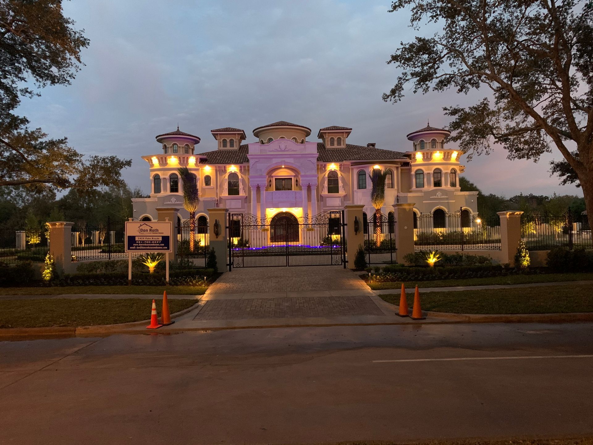 A large house is lit up at night with purple lights
