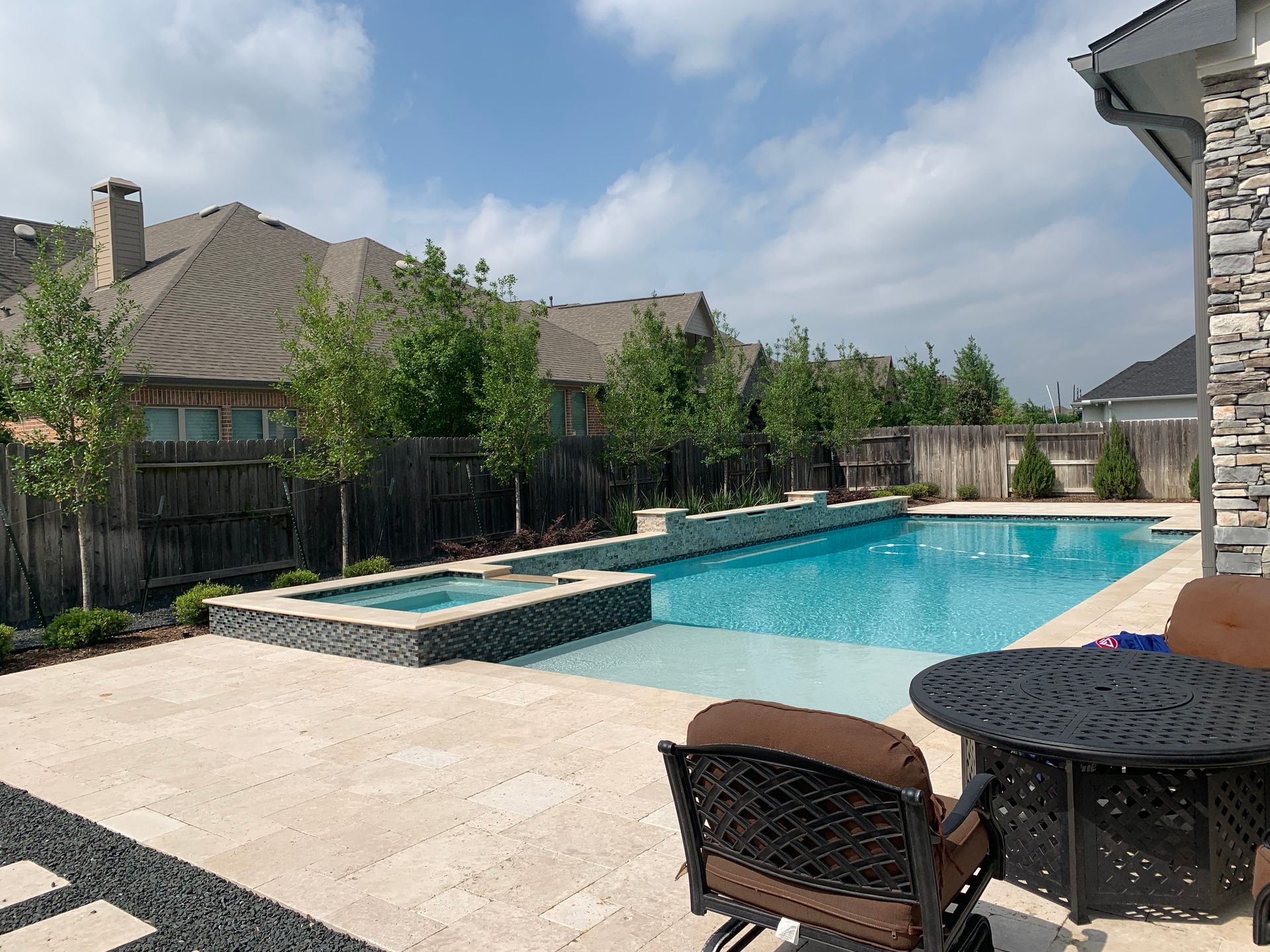 There is a large swimming pool in the backyard of a house.
