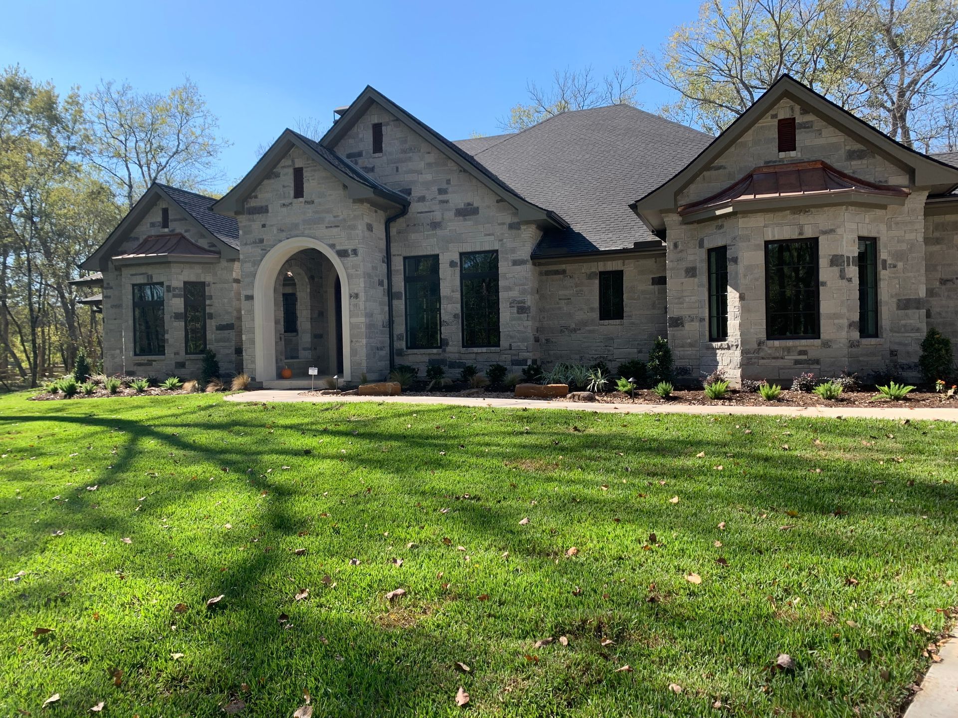 A large brick house with a lush green lawn in front of it.