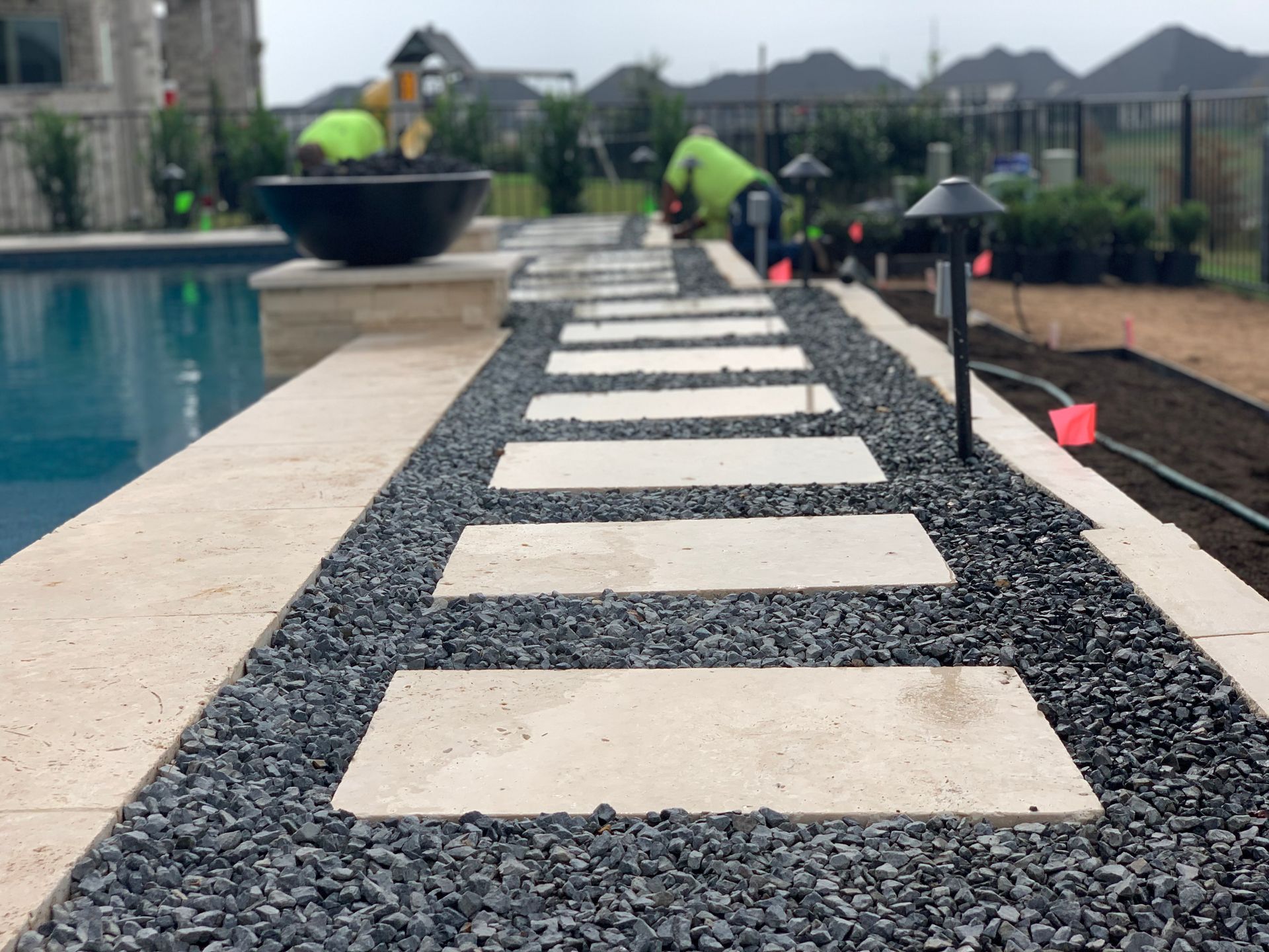 A row of stepping stones leading to a swimming pool