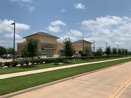 A large building with a lot of grass and trees in front of it.