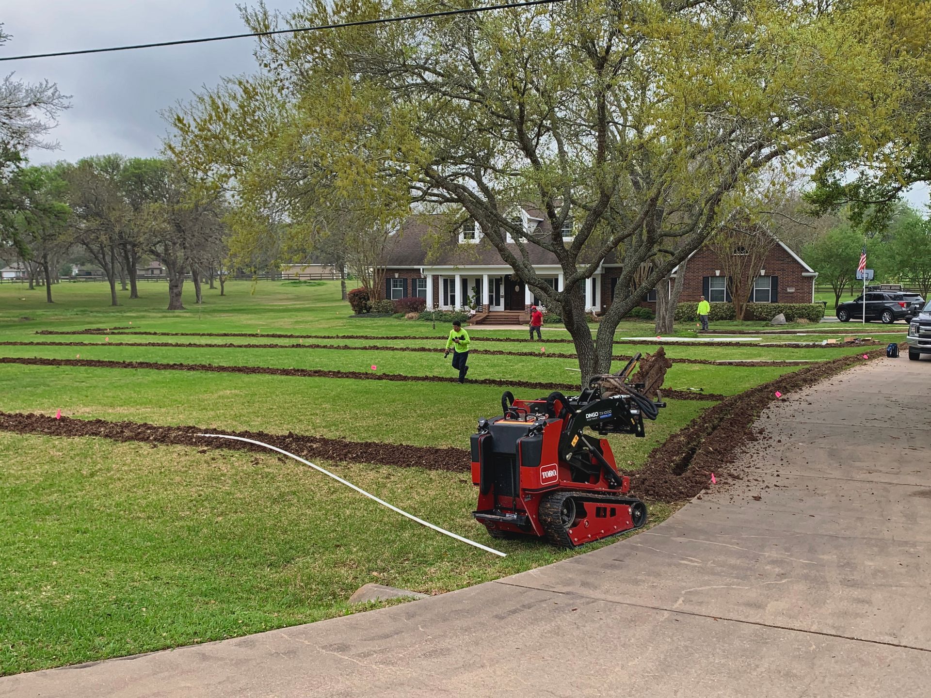 A lawn mower is parked on the side of the road in front of a house.
