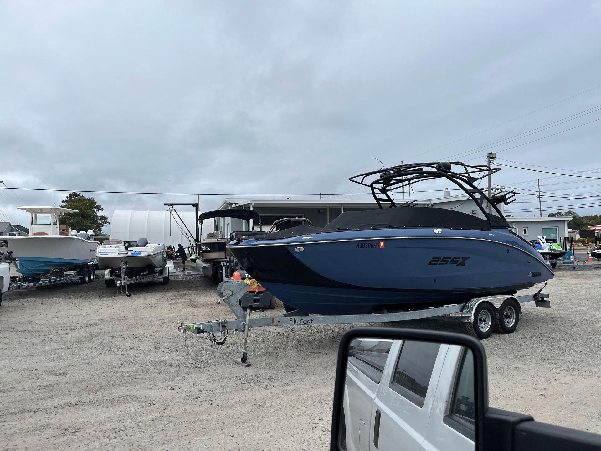 A boat is sitting on a trailer in a parking lot.