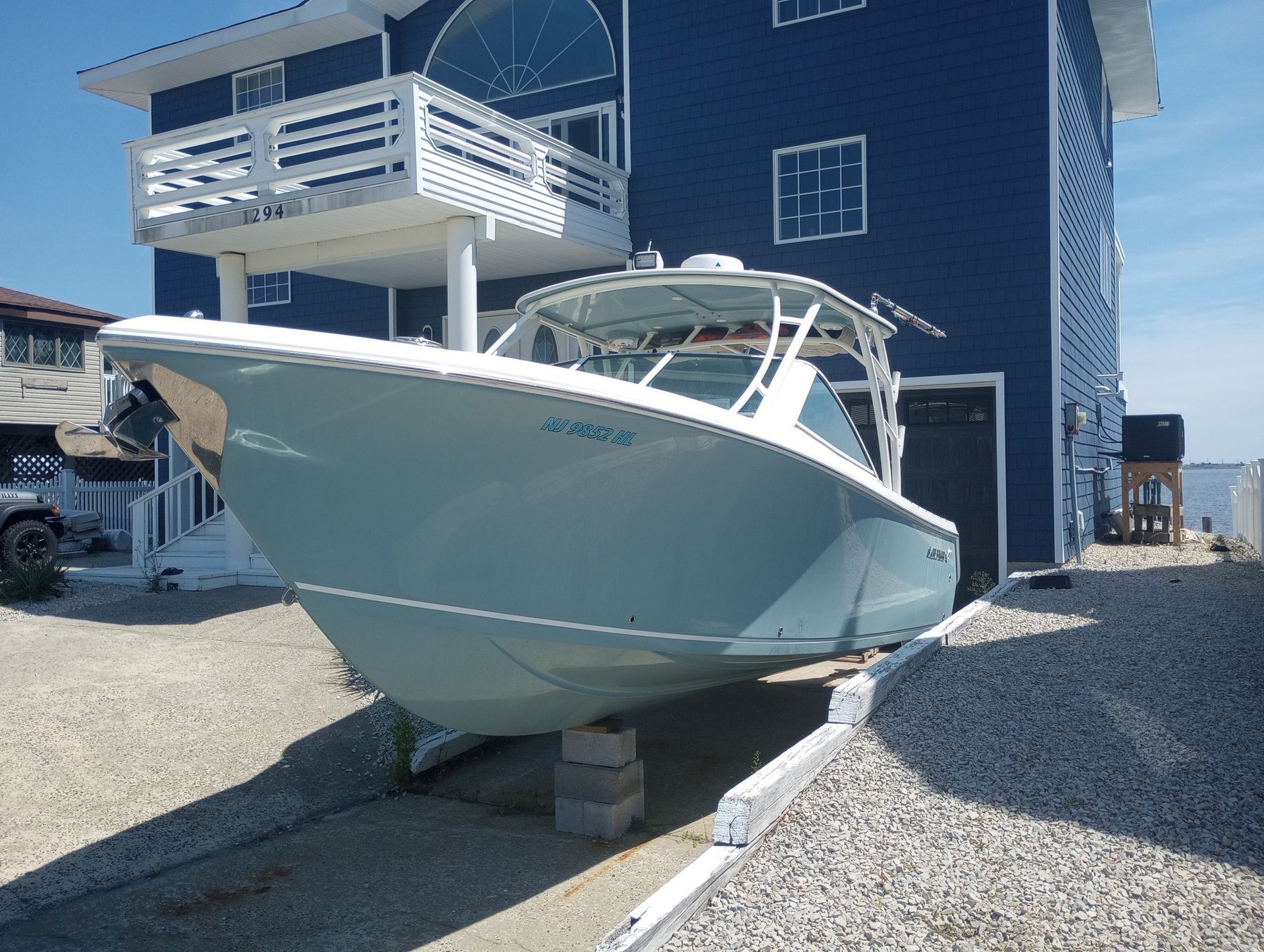 A boat is parked in front of a blue house