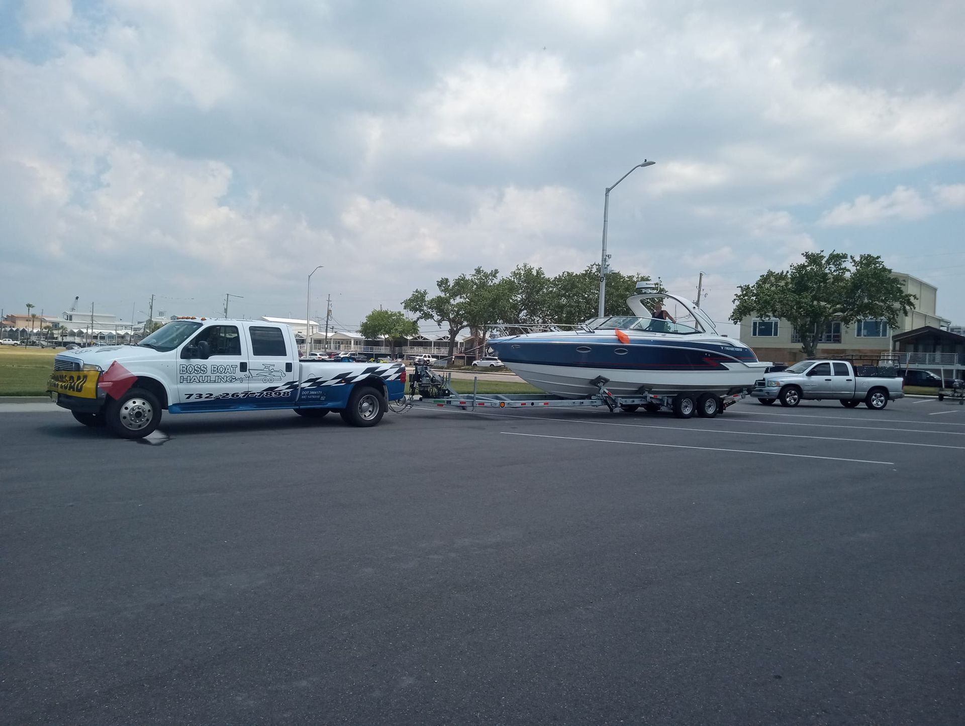 A tow truck is pulling a boat on a trailer