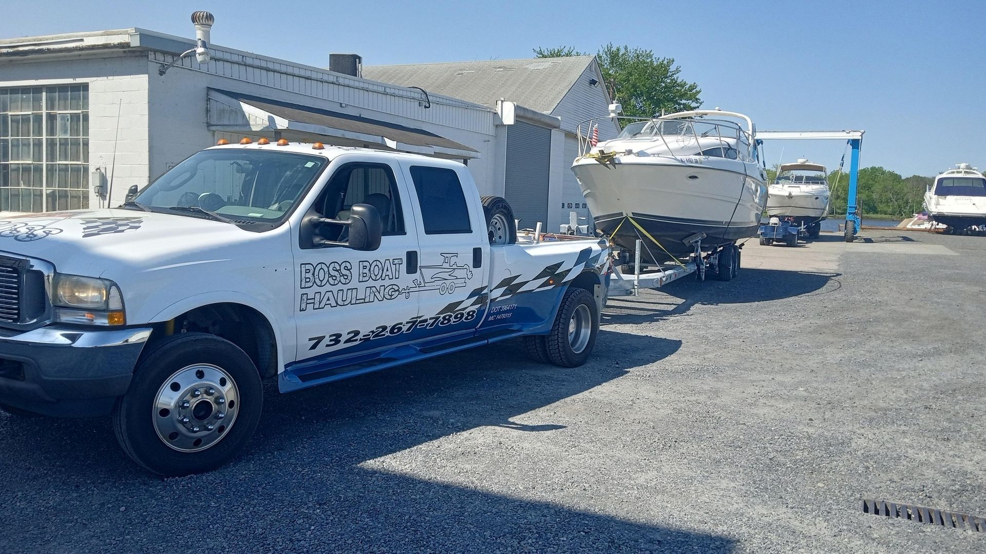 A tow truck is carrying a boat on a trailer.
