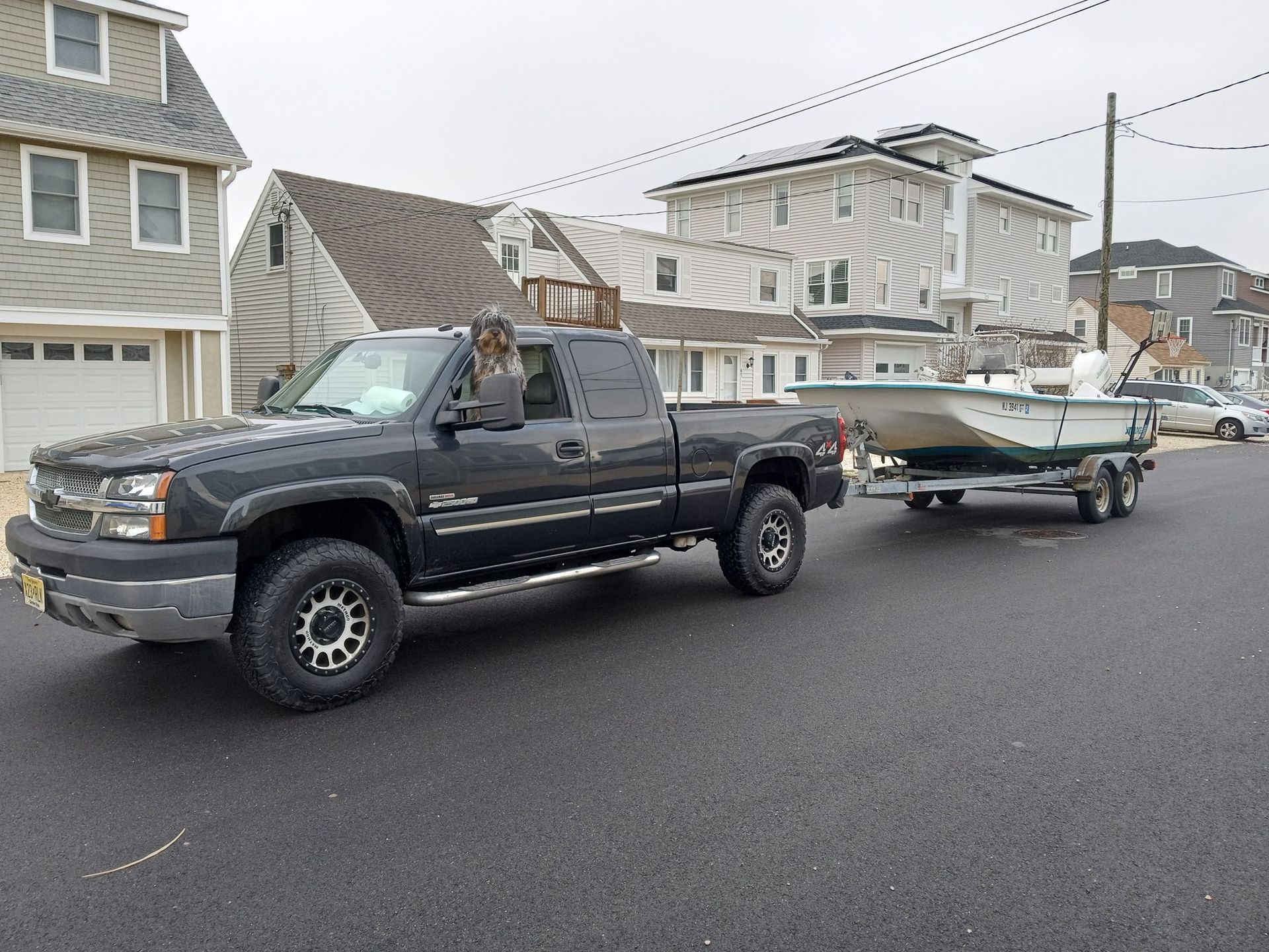A black truck is pulling a boat on a trailer
