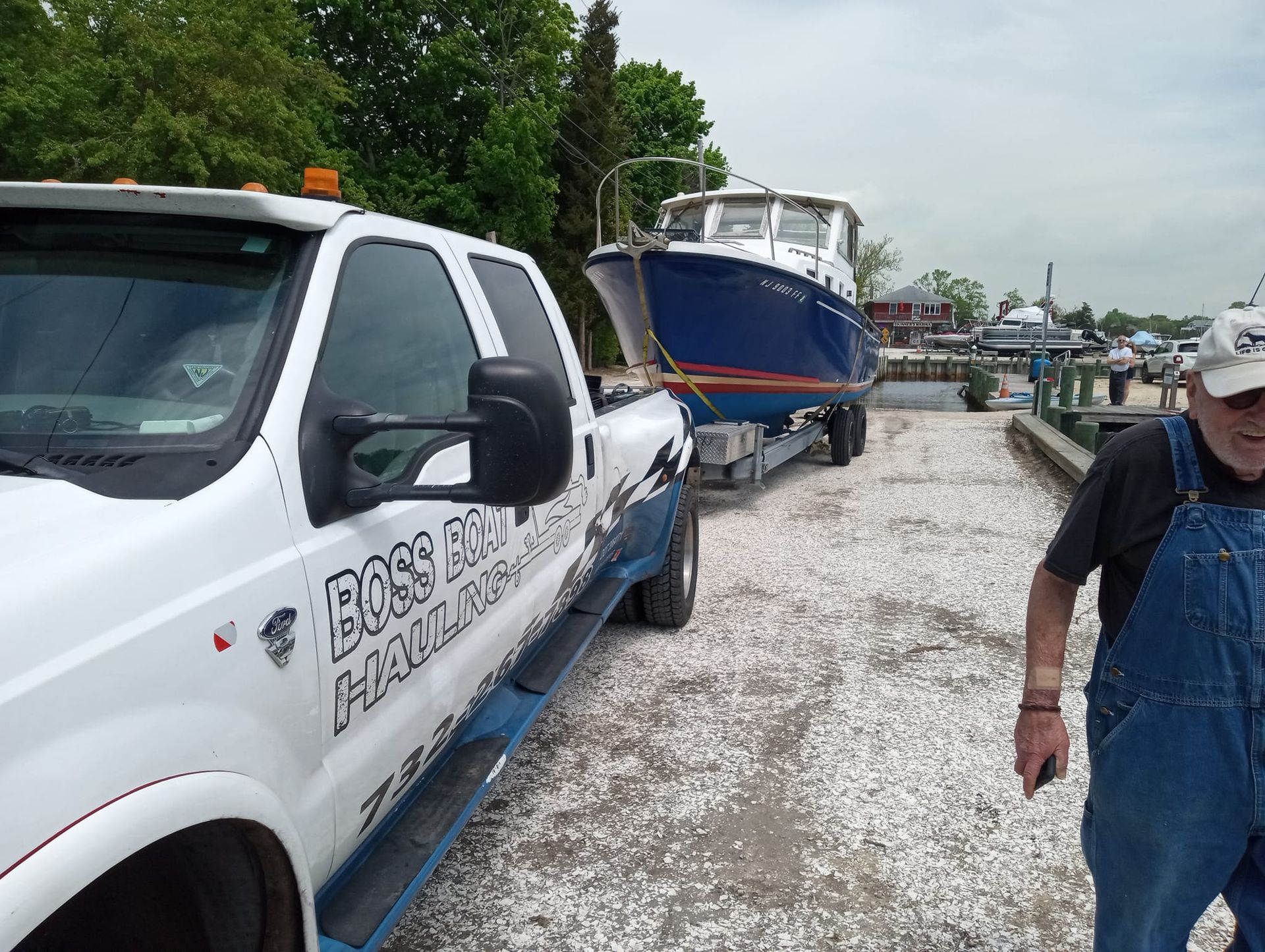 A man standing next to a white truck that says boss on the side