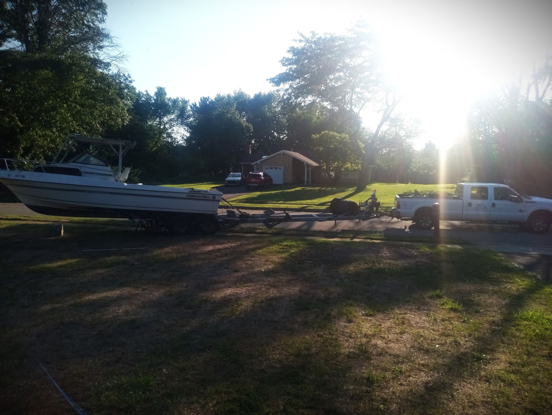 A white truck is pulling a boat on a trailer