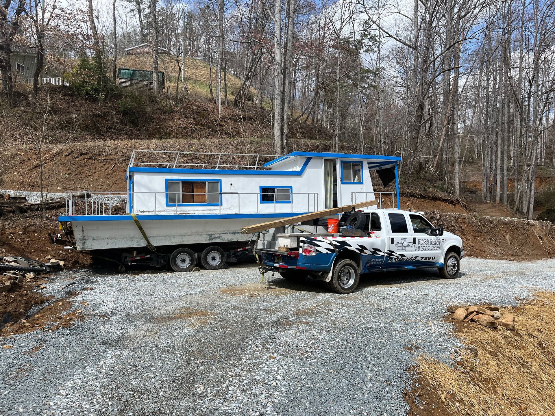 A white truck is towing a boat on a trailer.