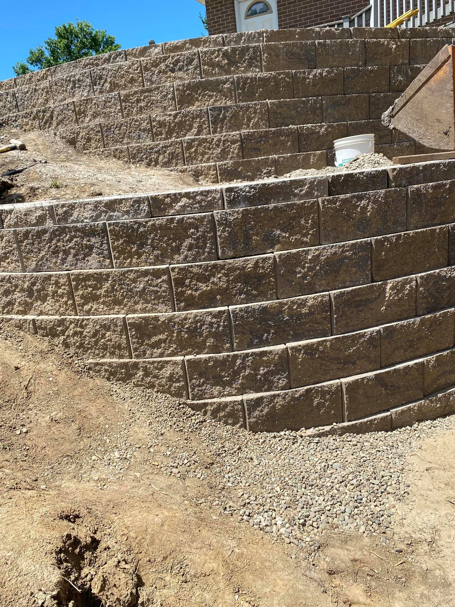 A brick wall is being built in front of a house