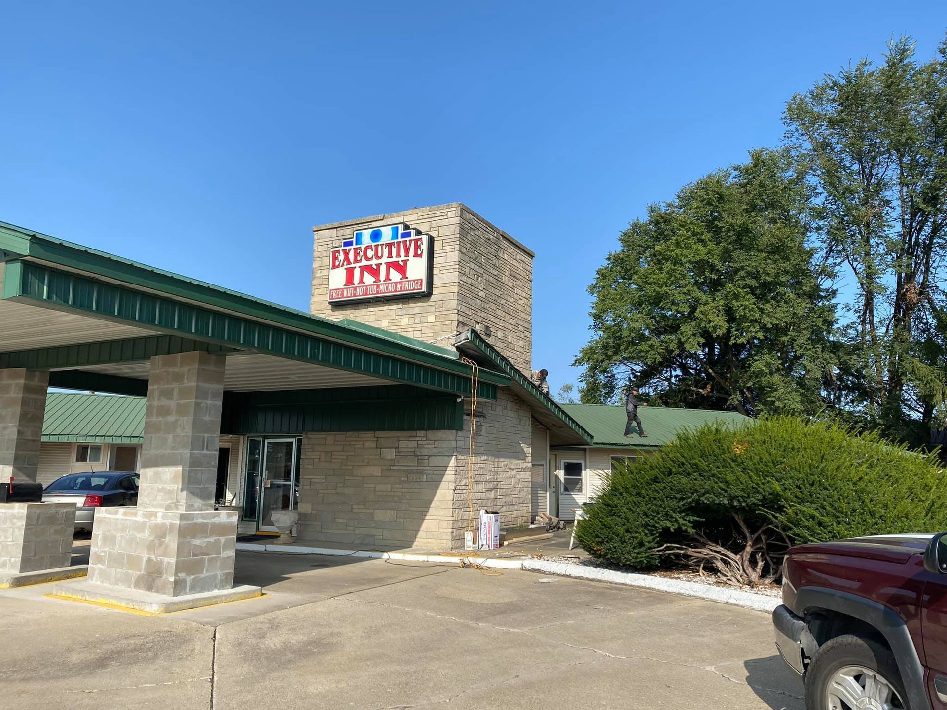 A red truck is parked in front of a motel.