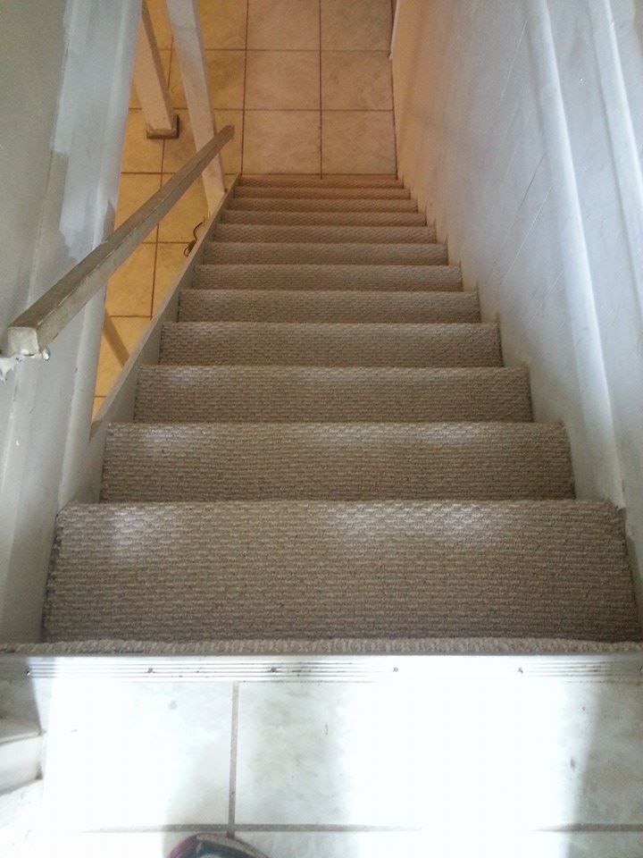 A set of stairs with a carpeted floor and a railing.