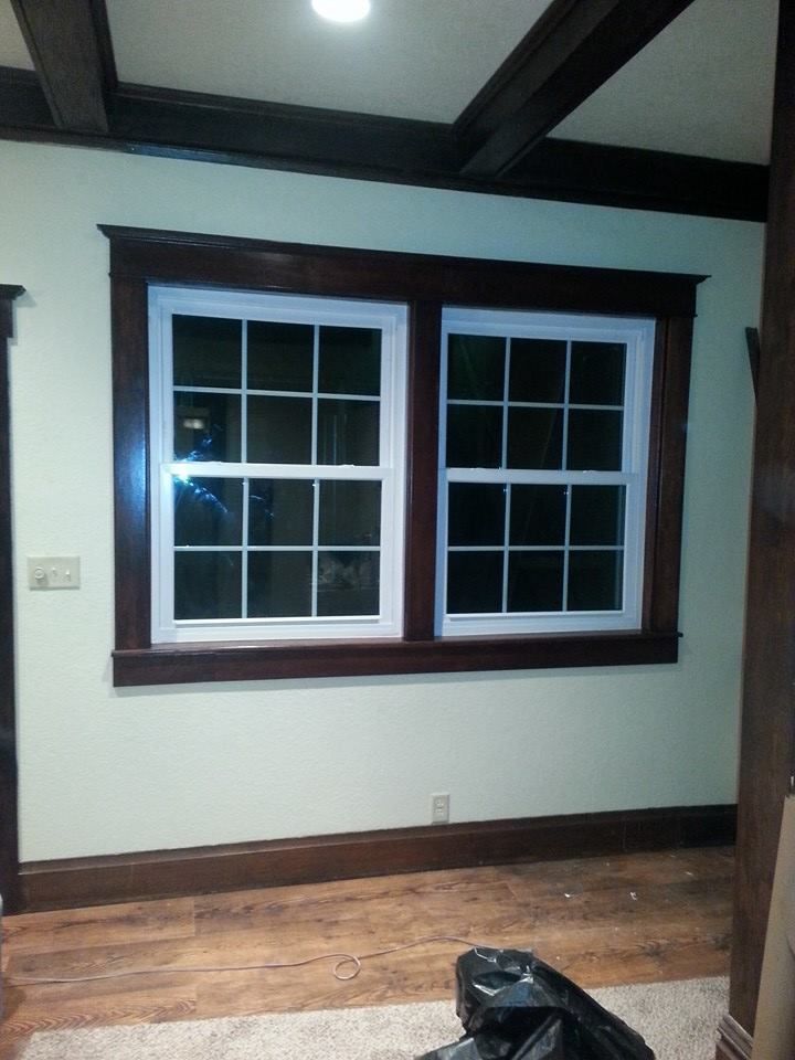 A room with two windows and a bag on the floor