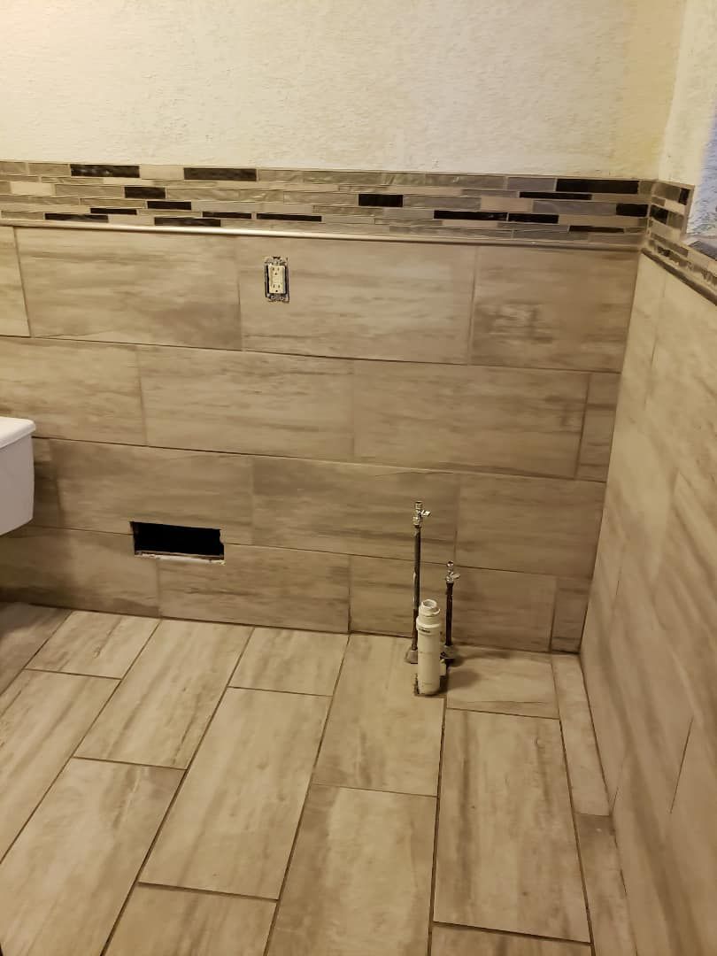A bathroom with a toilet , sink , and tile floor.