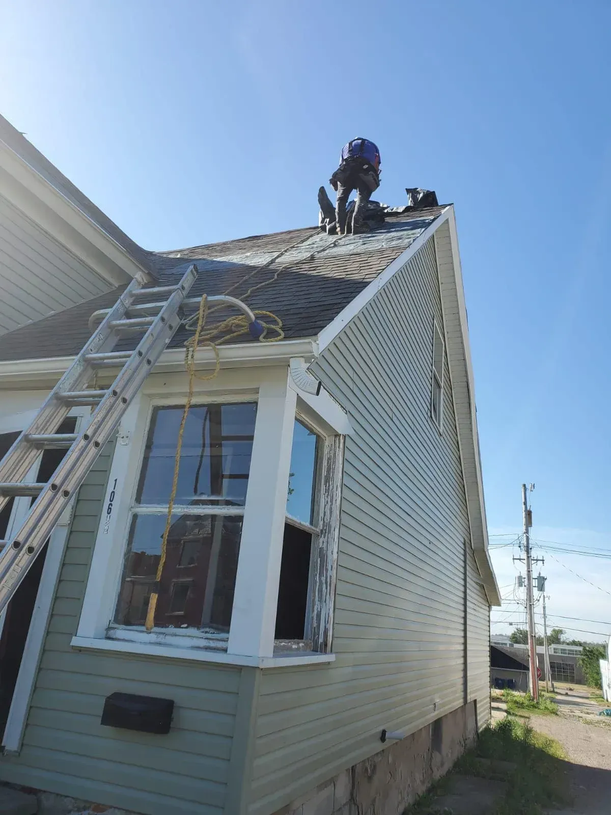 A man is working on the roof of a house.