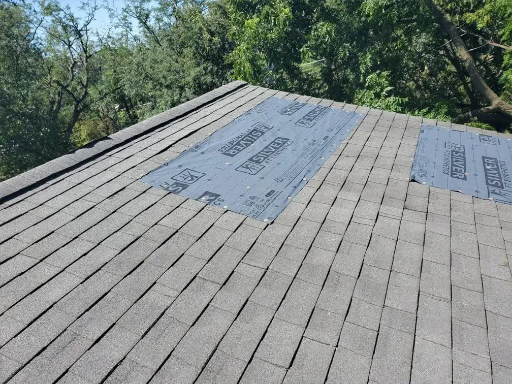A close up of a roof with a piece of shingles on it.