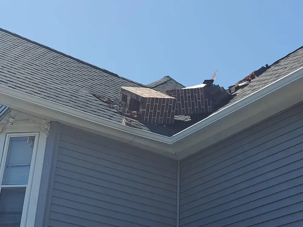 A house with a roof that has been damaged by a storm.