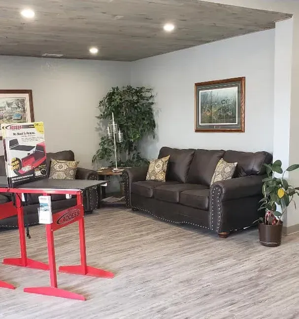 A living room with a brown couch and a red table