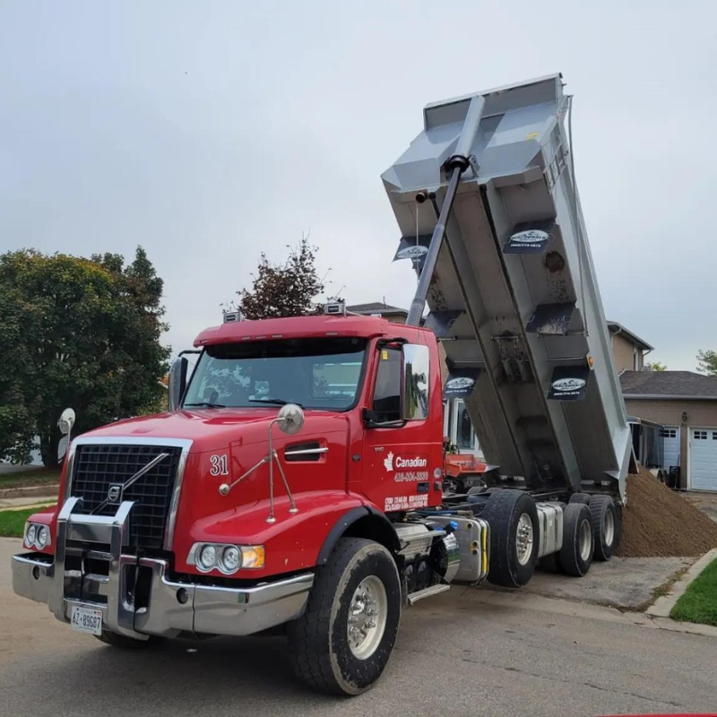 A red dump truck is parked in front of a house