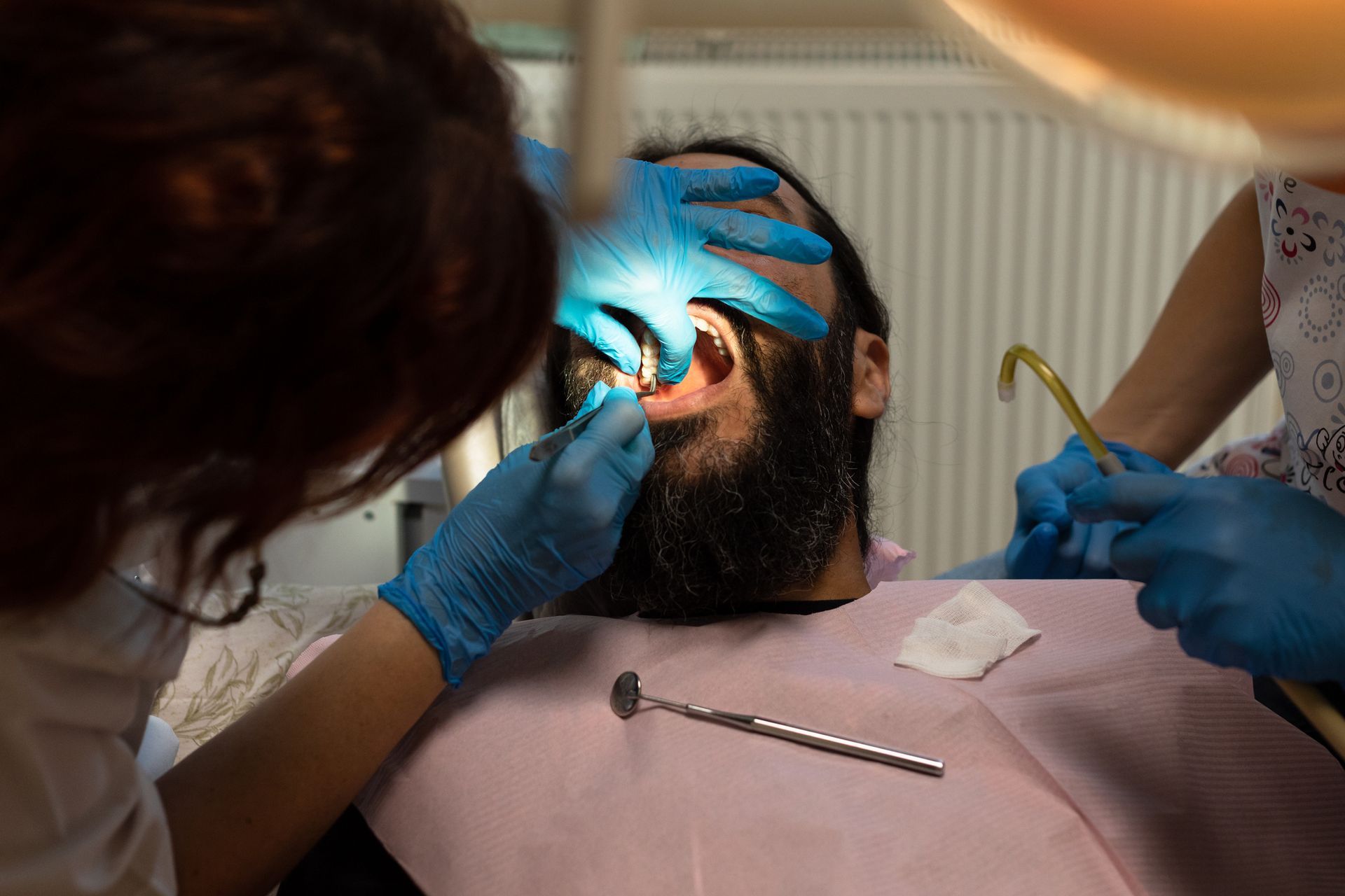 A dentist places a dental implant in the mouth of her patient.