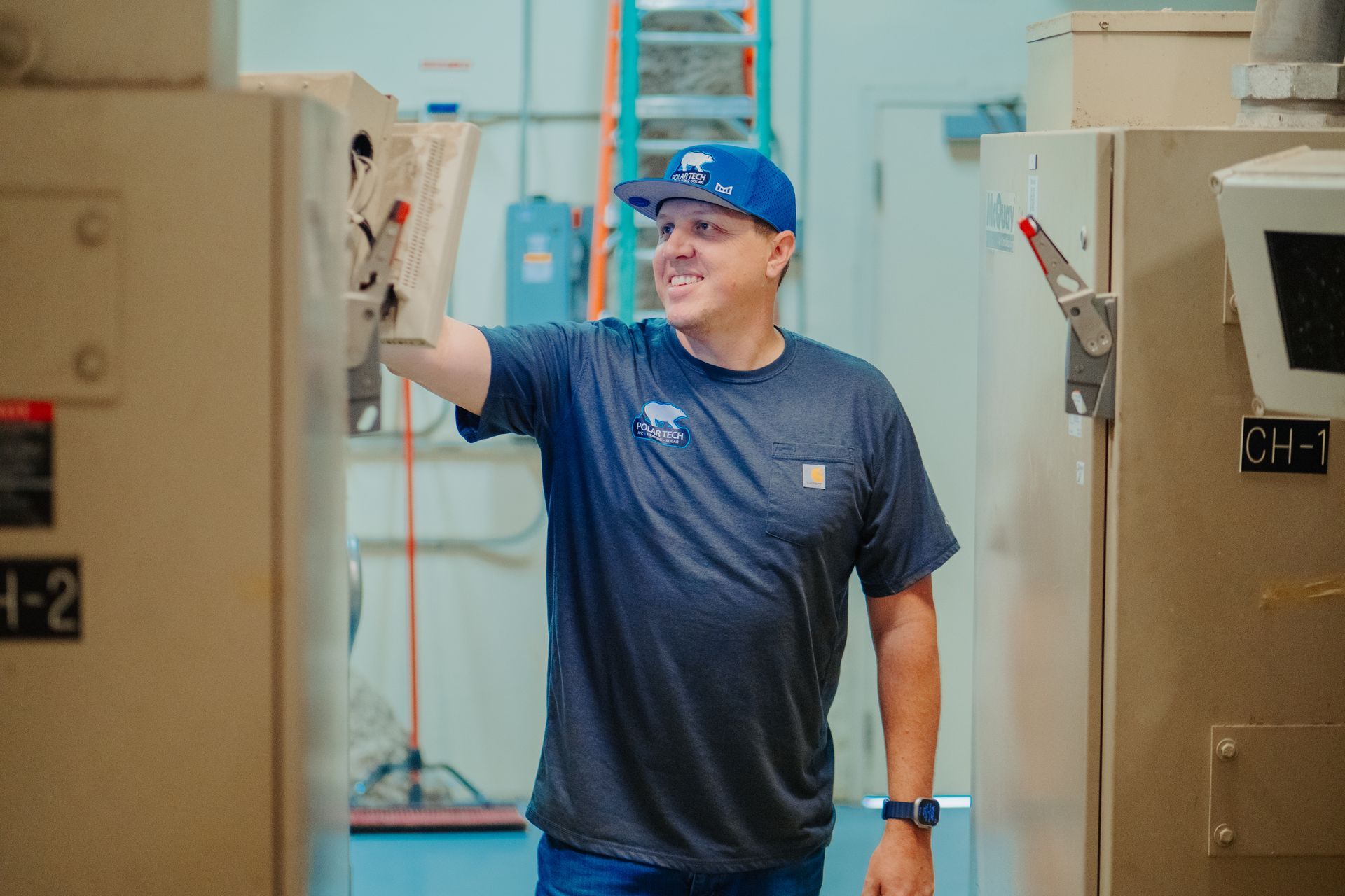 Two men are working on an air conditioner outside of a brick building.