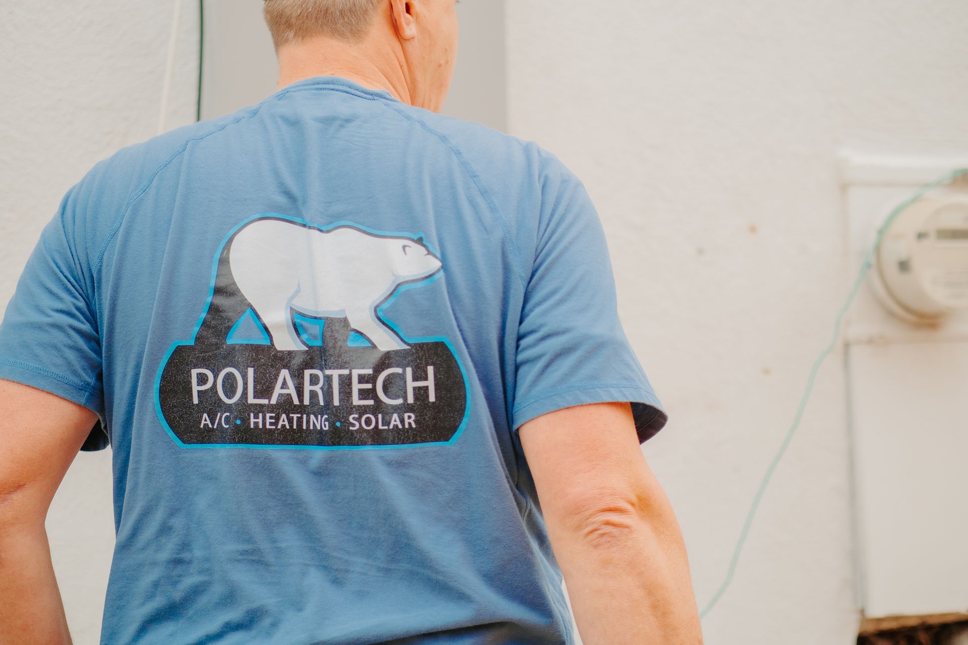 A woman and a child are sitting on a window sill looking out the window.
