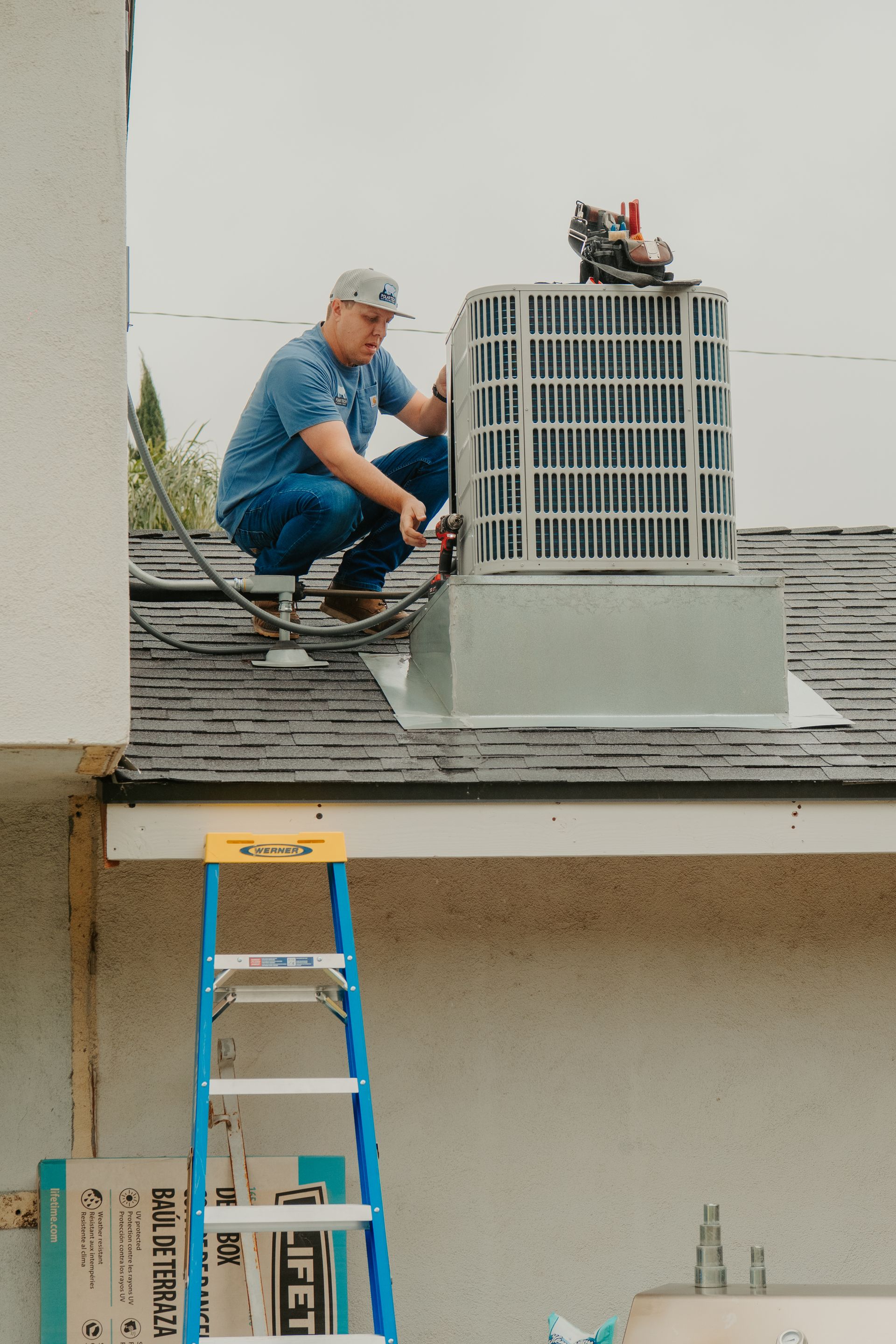 An air conditioner is sitting on top of a concrete block.