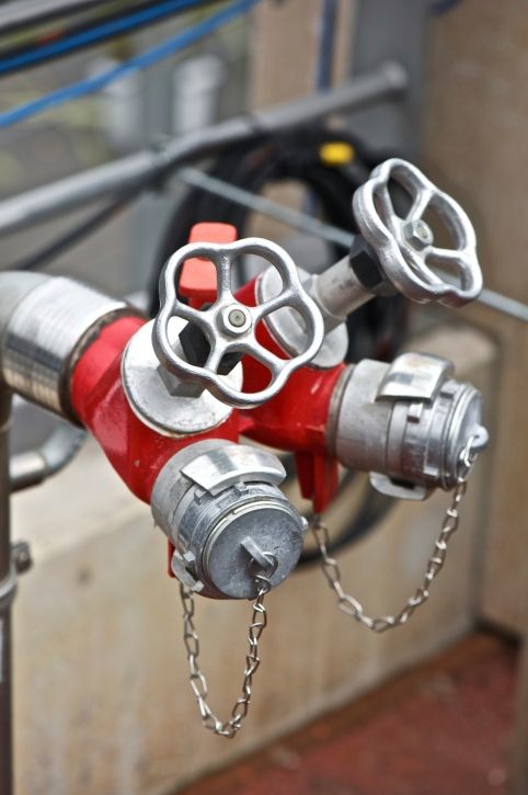 Un primer plano de una boca de incendios con dos válvulas adjuntas