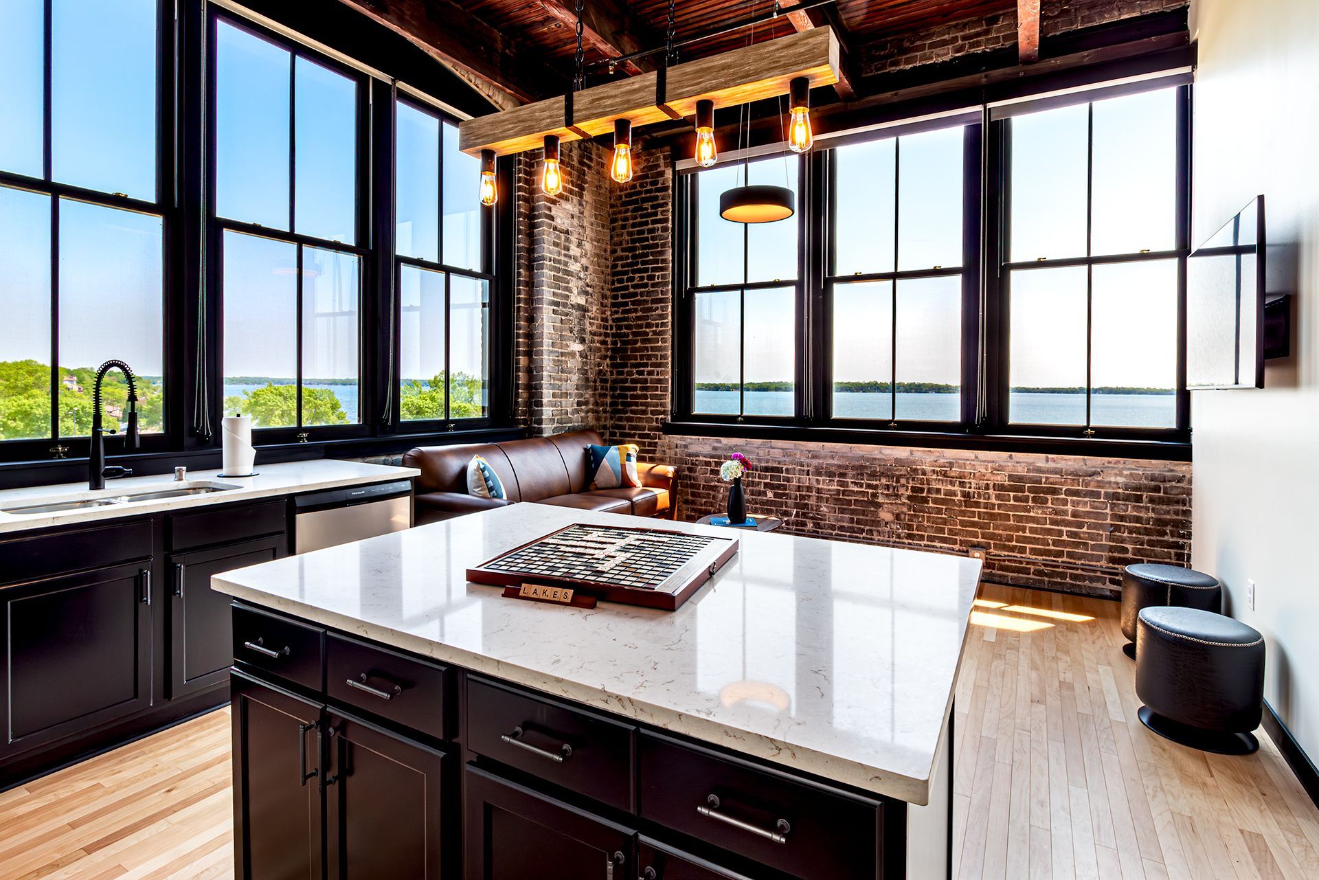 Modern style kitchen and living room at The Saddlery Madison, featuring exposed brick walls, la