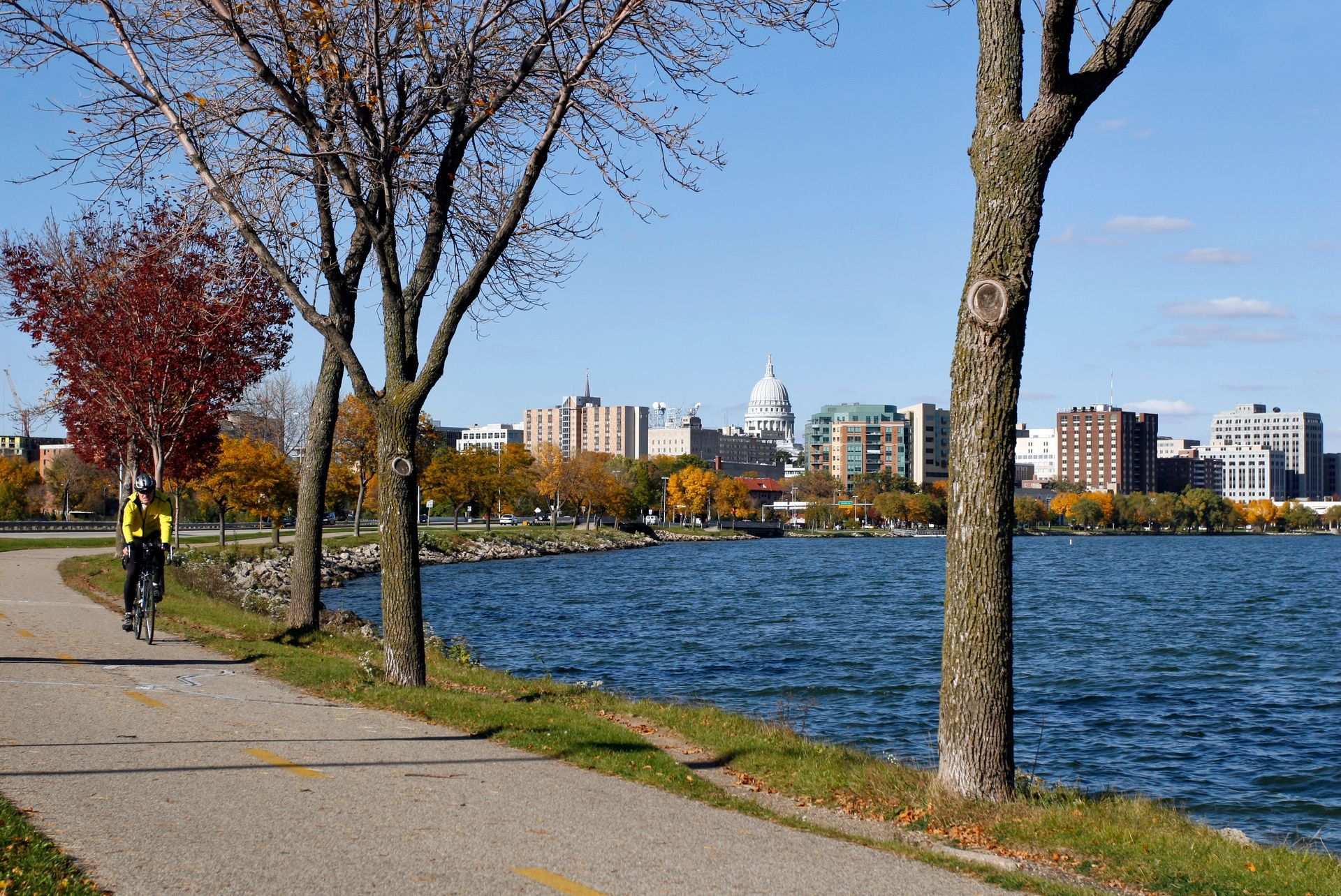 Cyclist on Lake Monona bike path with Wisconsin State Capitol in Madison, Wisconsin.