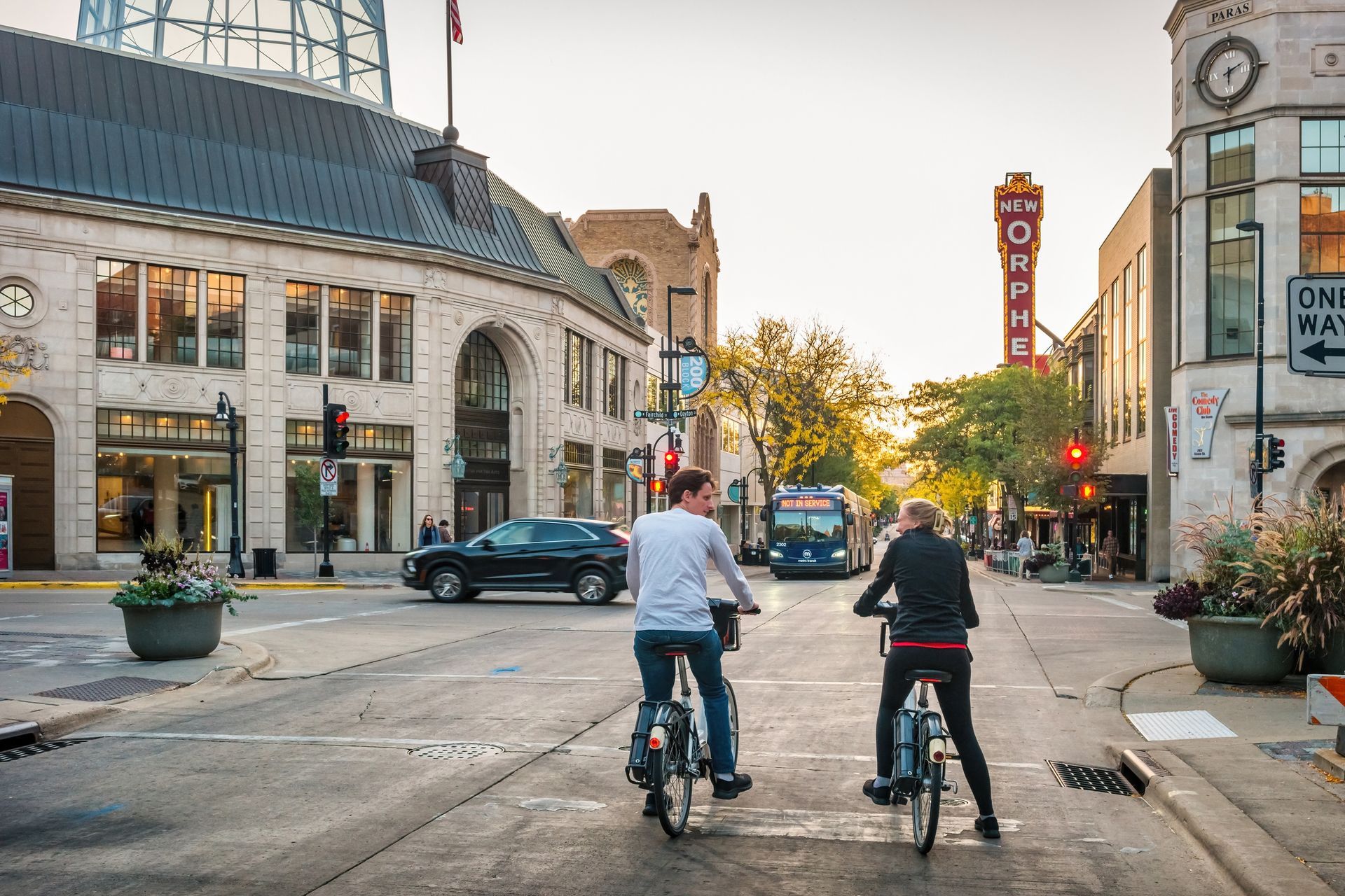 Couple biking through downtown Madison, Wisconsin near the Orpheum Theater.