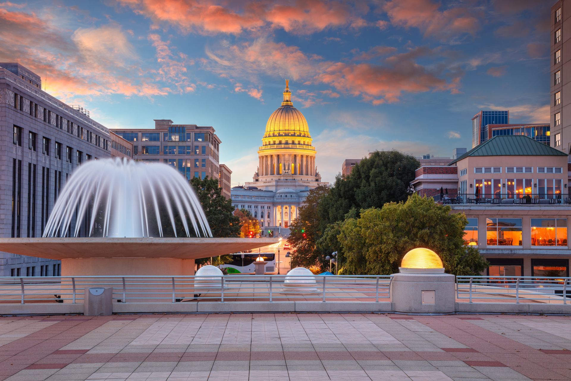 Wisconsin State Capitol building at sunset with a fountain in the foreground in downtown Madison.