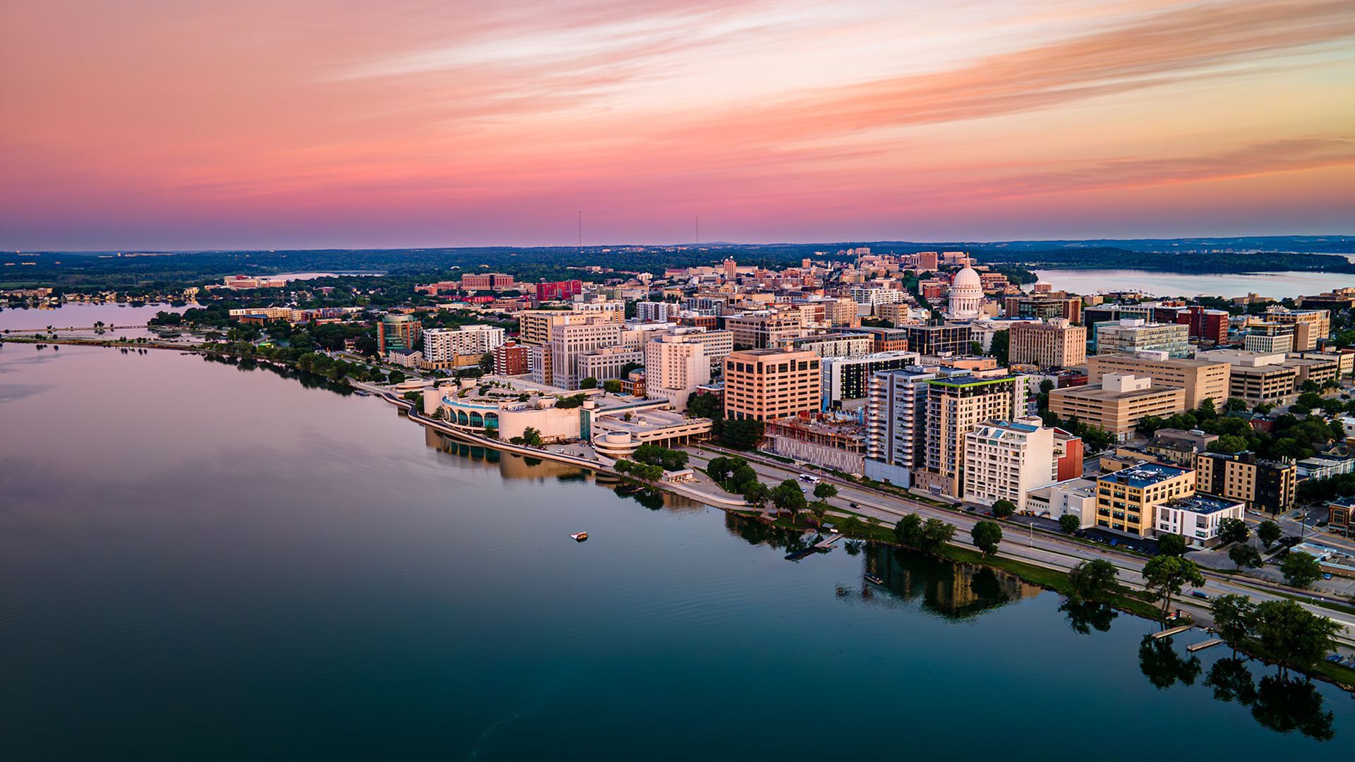 Aerial view of downtown Madison, Wisconsin at sunset with the Wisconsin State Capitol and Lake Monona in the foreground