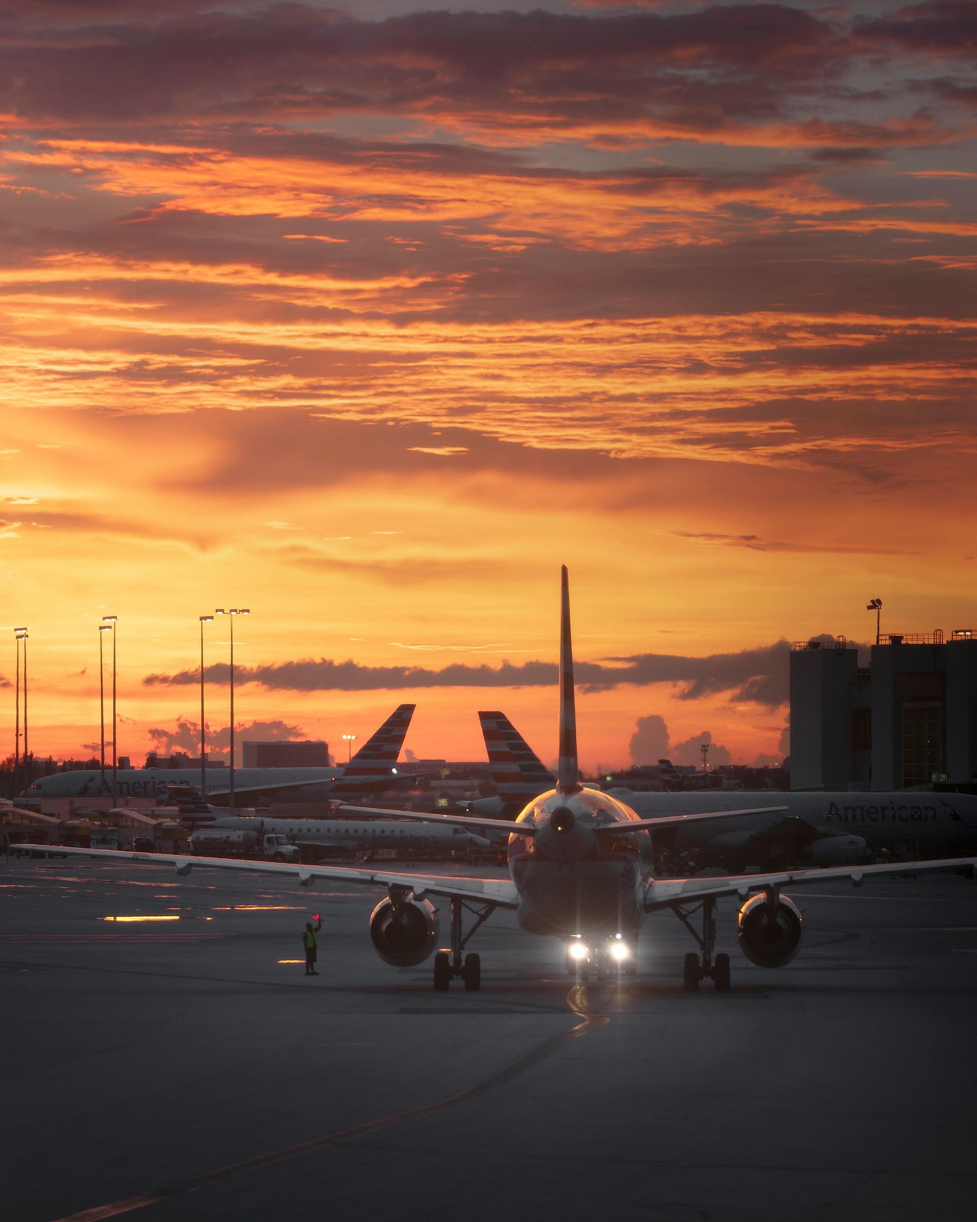 A plane is parked on a runway at sunset