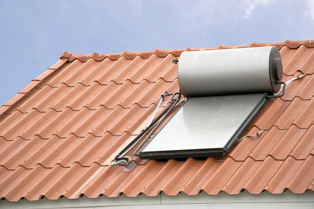 A Solar Water Heater Is Mounted On The Roof Of A House — Malouf Plumbing In Pie Creek, QLD