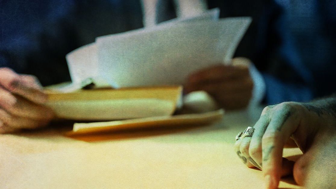 a person is sitting at a table holding a piece of paper .